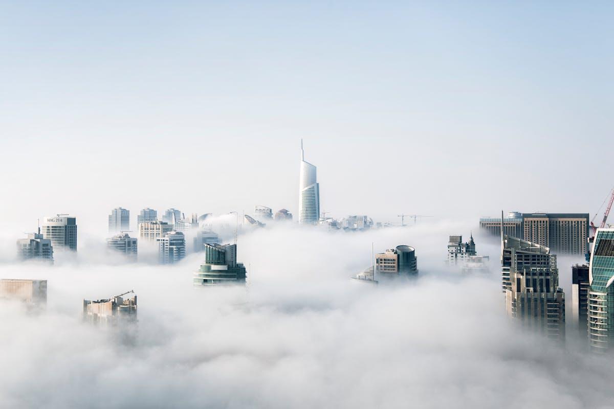 Picture of tall buildins covered by clouds